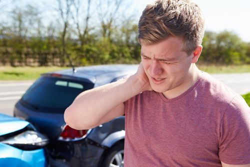 jonge man grijpt naar pijnlijke nek na botsing auto